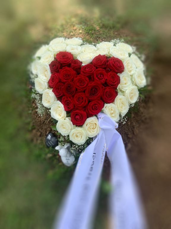 Blumenherz aus roten und weißen Rosen mit Trauerschleife